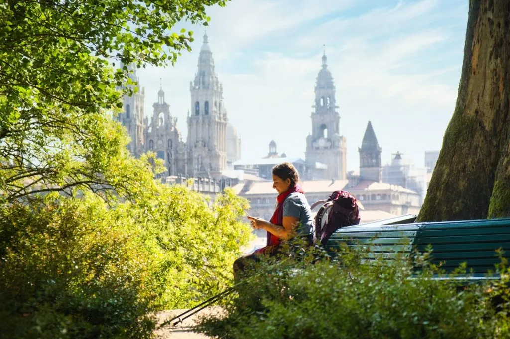 Tourist Woman On Pilgrimage At Santiago De Compostela With Phone
